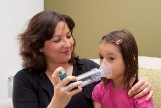 Asthma girl with mother using spacer